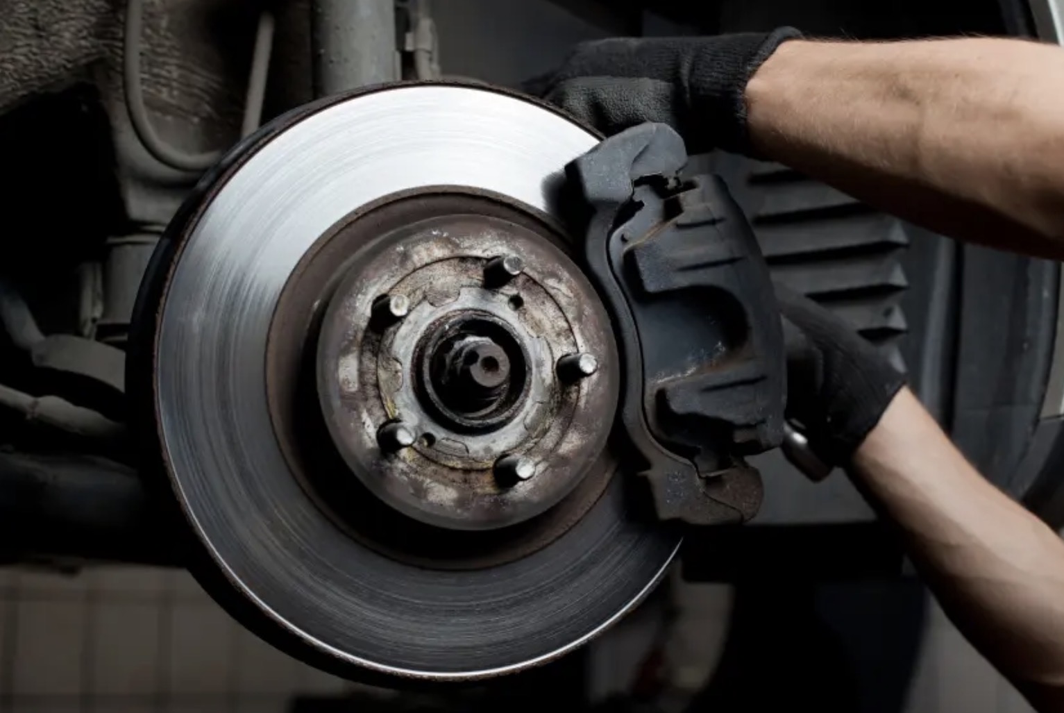 Mechanic fitting a new brake caliper and disc