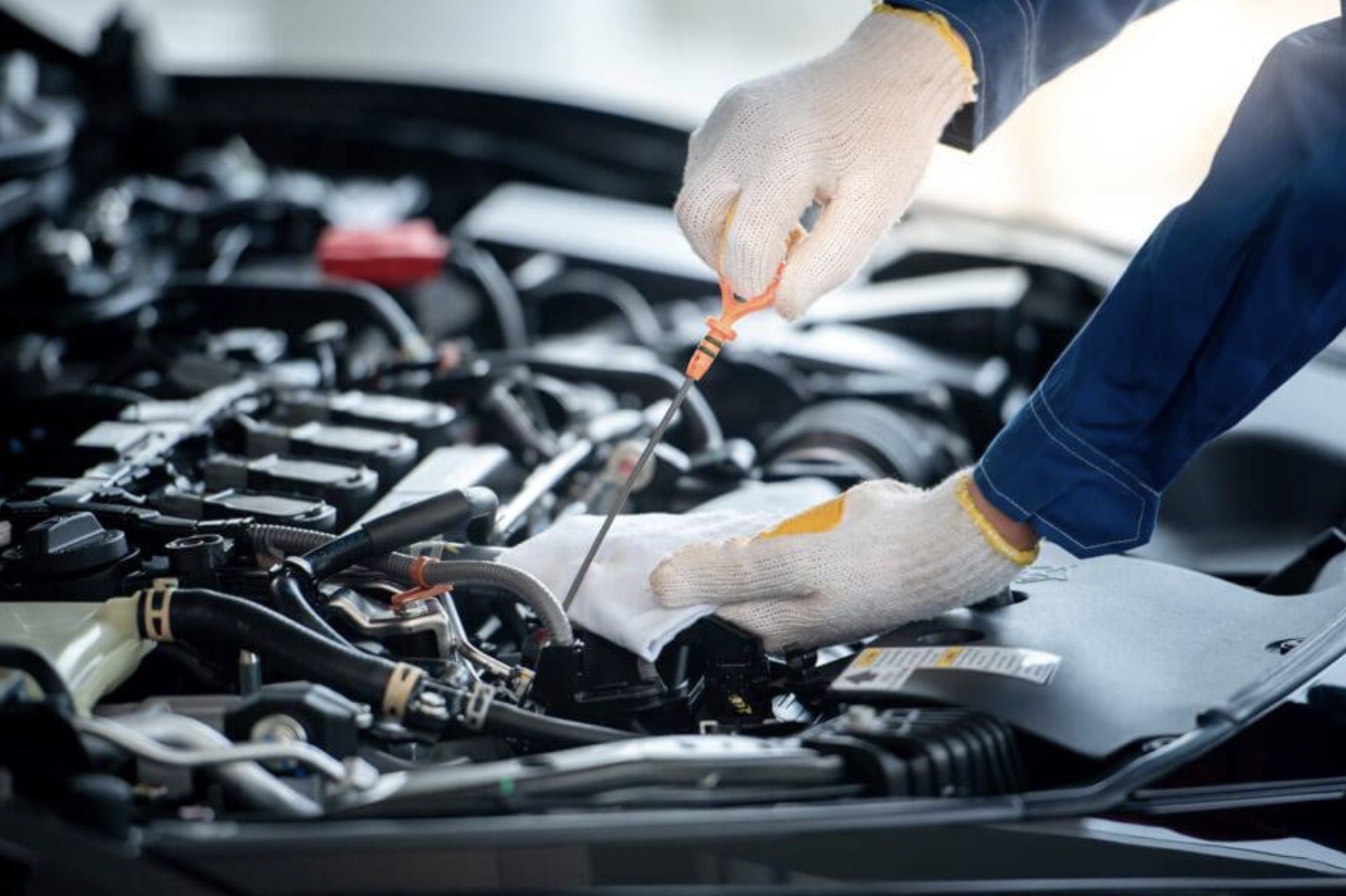 Mechanic checking engine oil level during a service