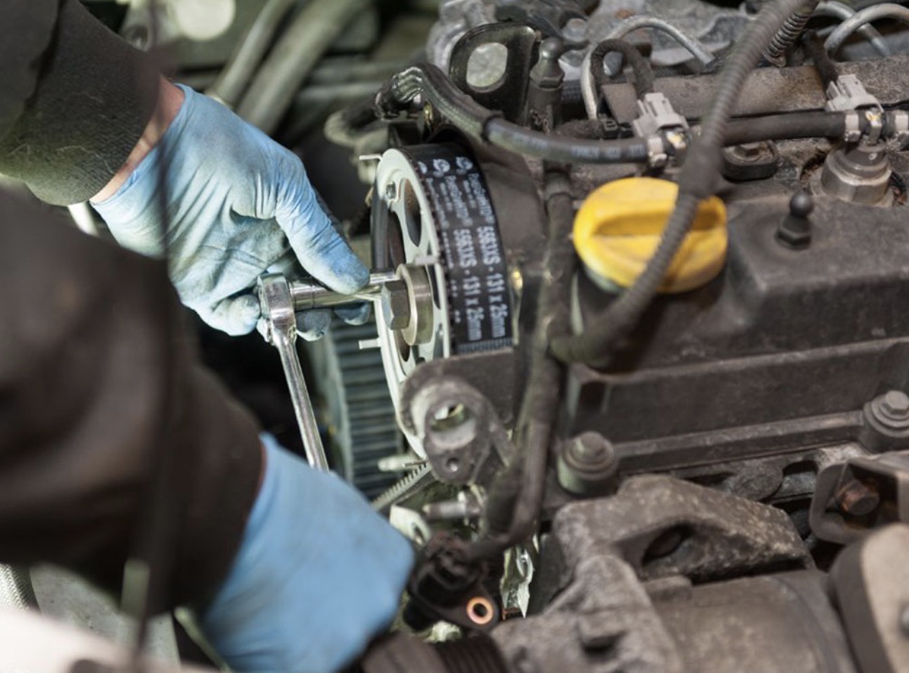 Mechanic tightening an engine belt tensioner
